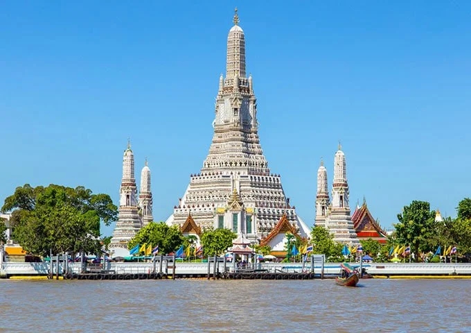 Wat Arun from the water in late afternoon. The photograph people want is from a boat, not from a traffic jam on the bridge.